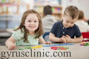 Two little children playing with toy letters, as a way to help lea how to spell.